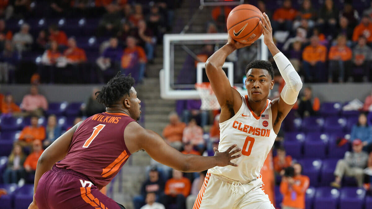 Clemson’s Clyde Trapp looks to pass while defended by Virginia Tech’s Isaiah Wilkins during the first half of an NCAA college basketball game Saturday, Feb. 9, 2019, in Clemson, S.C.. (Clemson won 59-51. AP Photo/Richard Shiro)