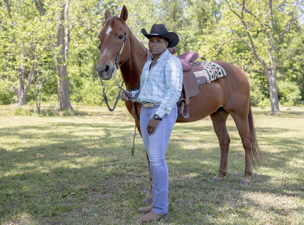 Kelly Sellers stands beside her horse Dudley, a 18-year-old Quarter Horse, on a ranch in Marion County. Sellers has been competing as a professional rider in barrel racing since 2002. Sellers has been participating in the festival for ten years and plans to drive from Marion County with her children for the event this year.