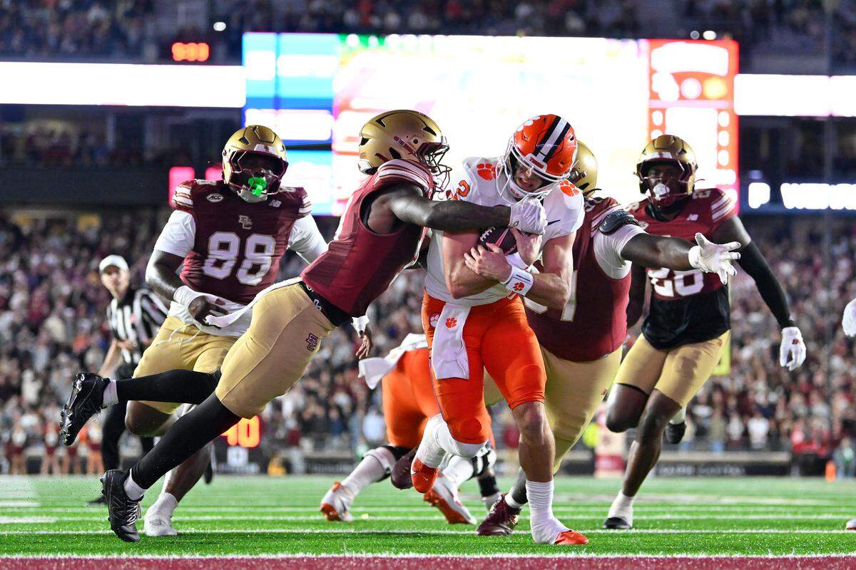 Clemson Tigers quarterback Cade Klubnik (2) runs through a tackle by Boston College Eagles defensive back Max Tucker (3) for a touchdown during the first half at Alumni Stadium.