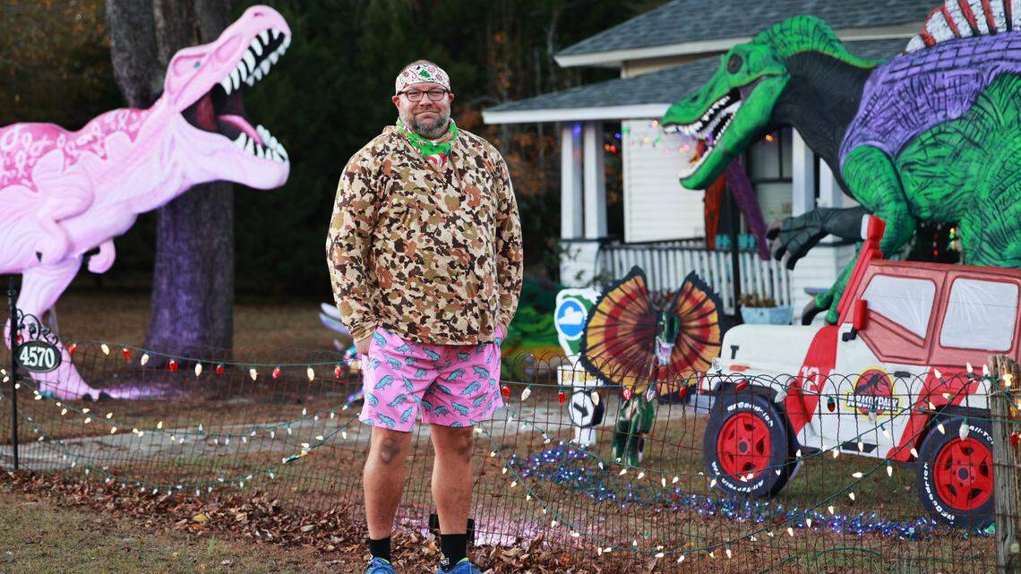 Christopher Price shows dinosaurs he made out of insulation foam outside his home on Wednesday, December 11, 2024. The dinosaurs are visible from Augusta Road in Lexington, South Carolina
