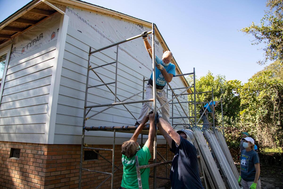 Habitat for Humanity volunteers assemble scaffolding outside a home in Cayce, South Carolina on Thursday, October 1, 2020. Volunteers have worked two days a week alongside contractors on the home since August.