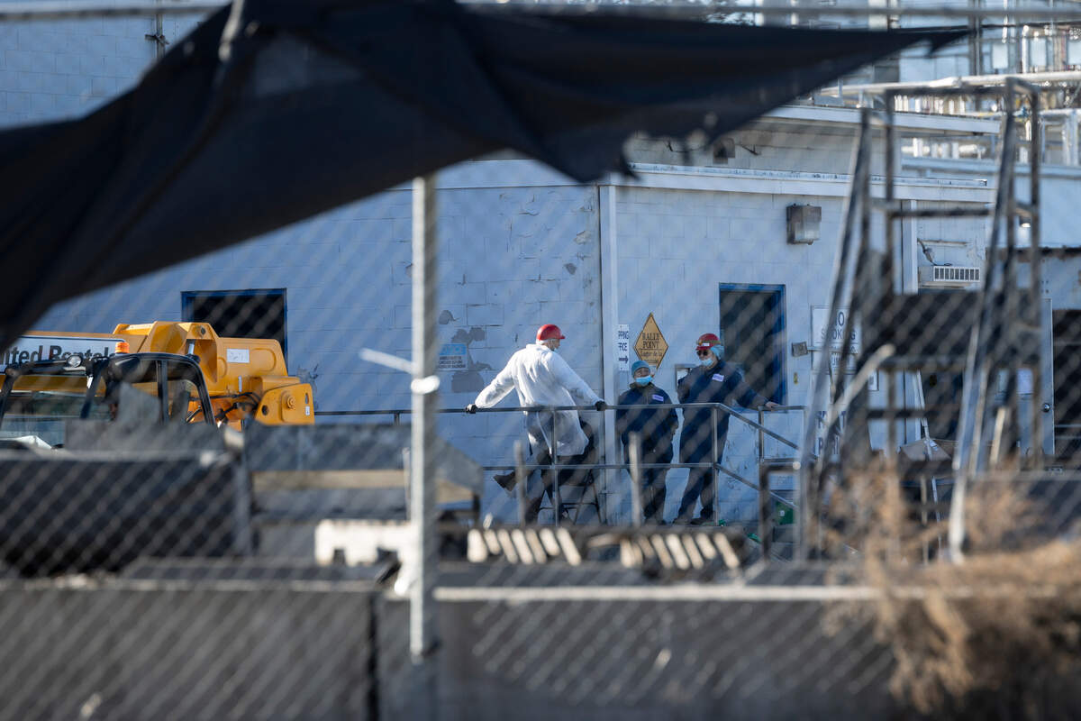 People stand outside Amick Farms processing plant in Saluda. The plant was heavily damaged by fire recently.
