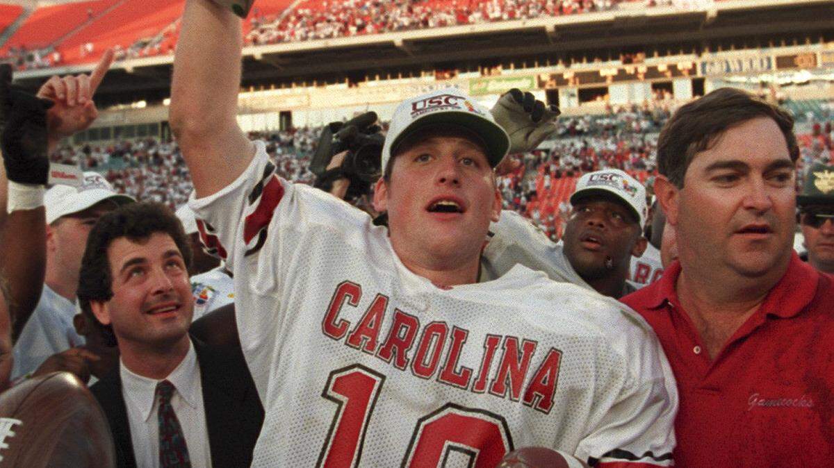 South Carolina's quarterback, Steve Taneyhill displays his MVP Trophy at the 1995 Carquest Bowl with Head Coach Brad Scott by his side.