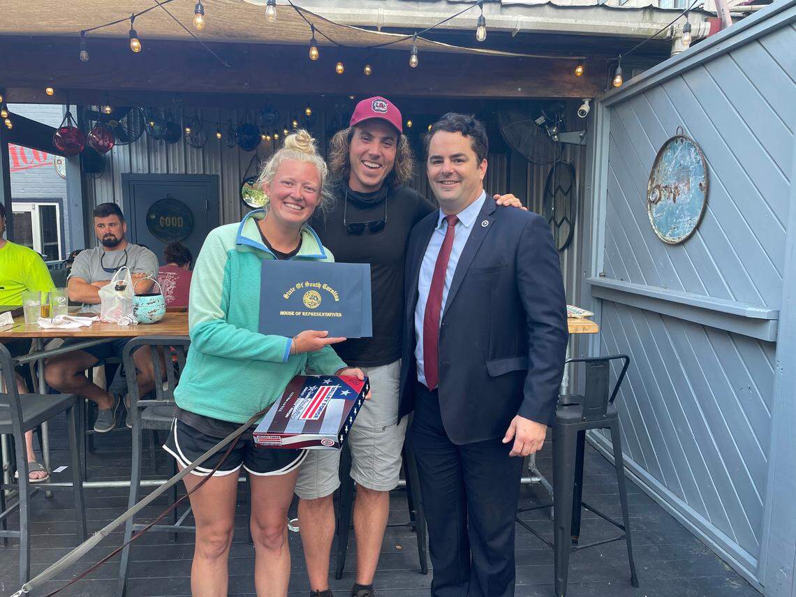 State Rep. Micah Caskey (right) presented Matt Grooms and Grace Nesseth with a State House flag and state commendation for their walk across the U.S. to support families dealing with illness and the nonprofit Time in a Bottle.
