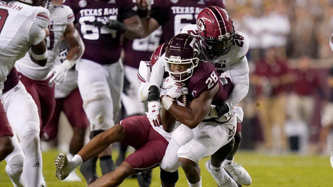 Texas A&M running back Isaiah Spiller (28) is tackled by South Carolina defensive back Darius Rush (28) after picking up a first down on a run during the first quarter of an NCAA college football game on Saturday, Oct. 23, 2021, in College Station, Texas. (AP Photo/Sam Craft)