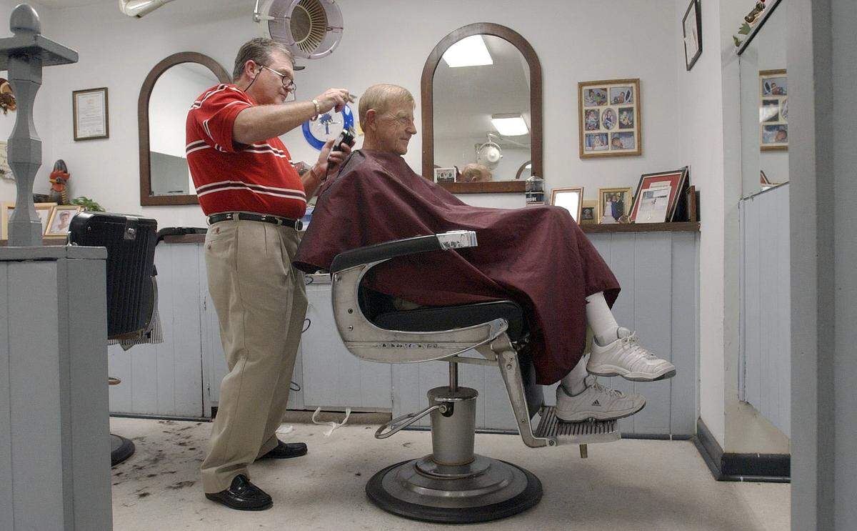 USC head coach Lou Holtz gets his hair cut on Sept. 25, 2003, by barber Ed Barnes at Kings Row in Five Points.