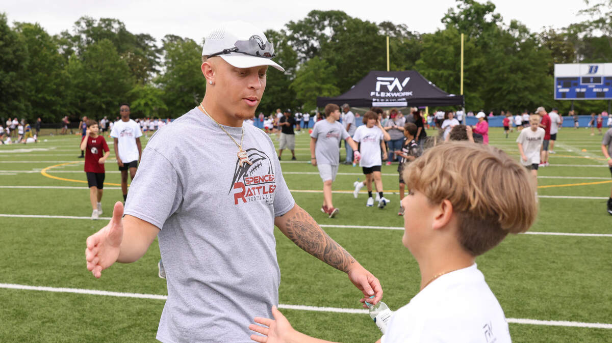 South Carolina quarterback Spencer Rattler is greeted by Cooper Hornick, 12, during the Spencer Rattler FlexWork Football Camp at Dreher High School in Columbia on Saturday, May 20, 2023.