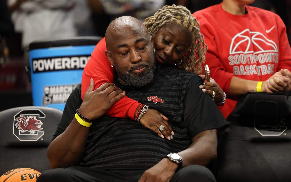 South Pointe girls basketball coach Stephanie Butler-Graham, back, hugs South Pointe boys basketball head coach Melvin Watson following his team’s loss to North Augusta in the SCHSL Class 4A Boys State Final at Colonial Life Arena in Columbia on Saturday, March 7, 2026.