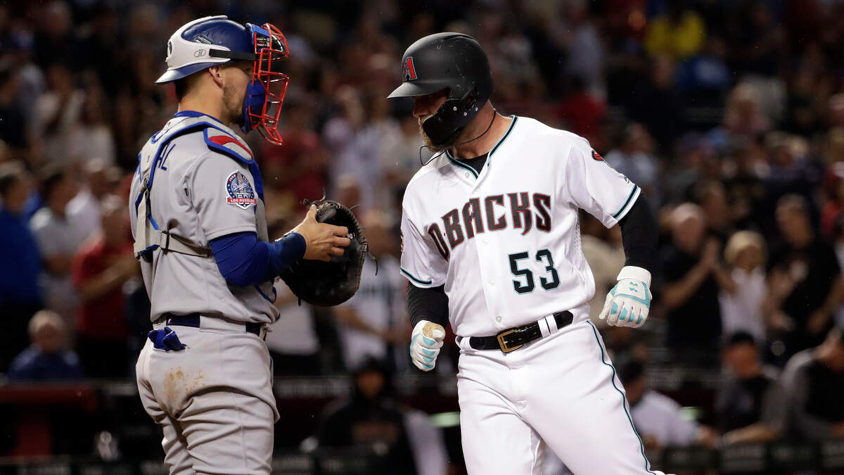 Arizona Diamondbacks Christian Walker (53) crosses the plate after hitting a solo home run as Los Angeles Dodgers catcher Yasmani Grandal waits during the fifth inning of a baseball game Tuesday, May 1, 2018, in Phoenix.