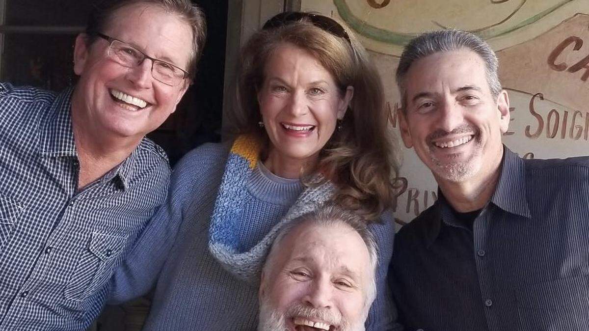 Charlie Golson during a visit to the restaurant now run by his children poses with staff members, from left, bartender Jeff Mix, server Jodie Adrian and manager Patrick Fille.