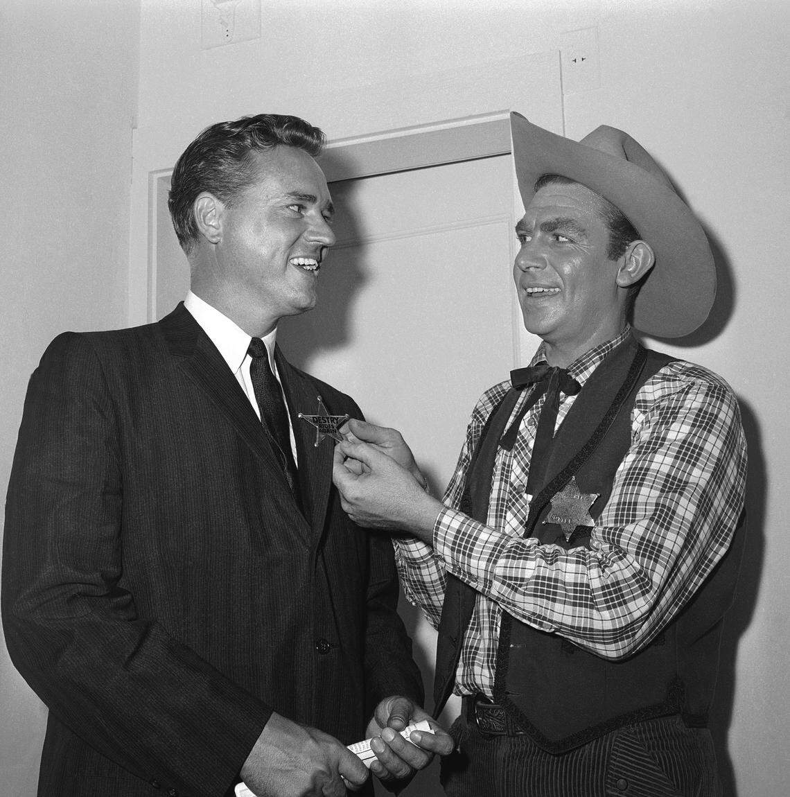 Andy Griffith, right, star of the Broadway musical ?Destry Rides Again? and a native of North Carolina, pins a badge on the lapel of Ernest F. Hollings, governor of South Carolina, after performance at night on May 21, 1959 in the Imperial Theater, New York. (AP Photo)