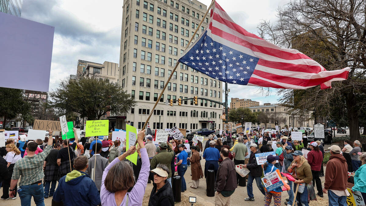 Elizabeth Johnson waves an upside-down American flag during a protest at the South Carolina State House on Tuesday, March 4, 2025. As America marks 250 years, Central Valley residents ask what defines being an American.