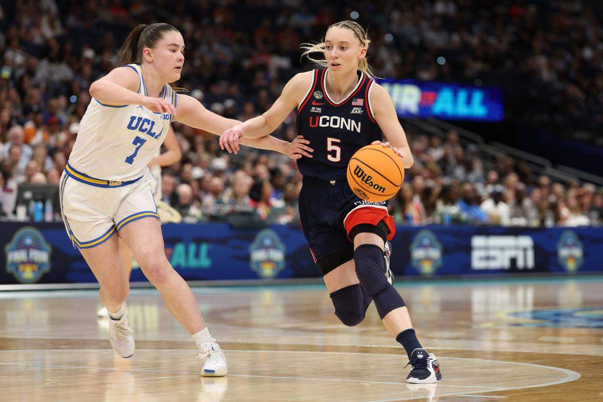 Apr 4, 2025; Tampa, FL, USA; Connecticut Huskies guard Paige Bueckers (5) dribbles against UCLA Bruins guard Elina Aarnisalo (7) during the third quarter in a semifinal of the women’s 2025 NCAA tournament at Amalie Arena.