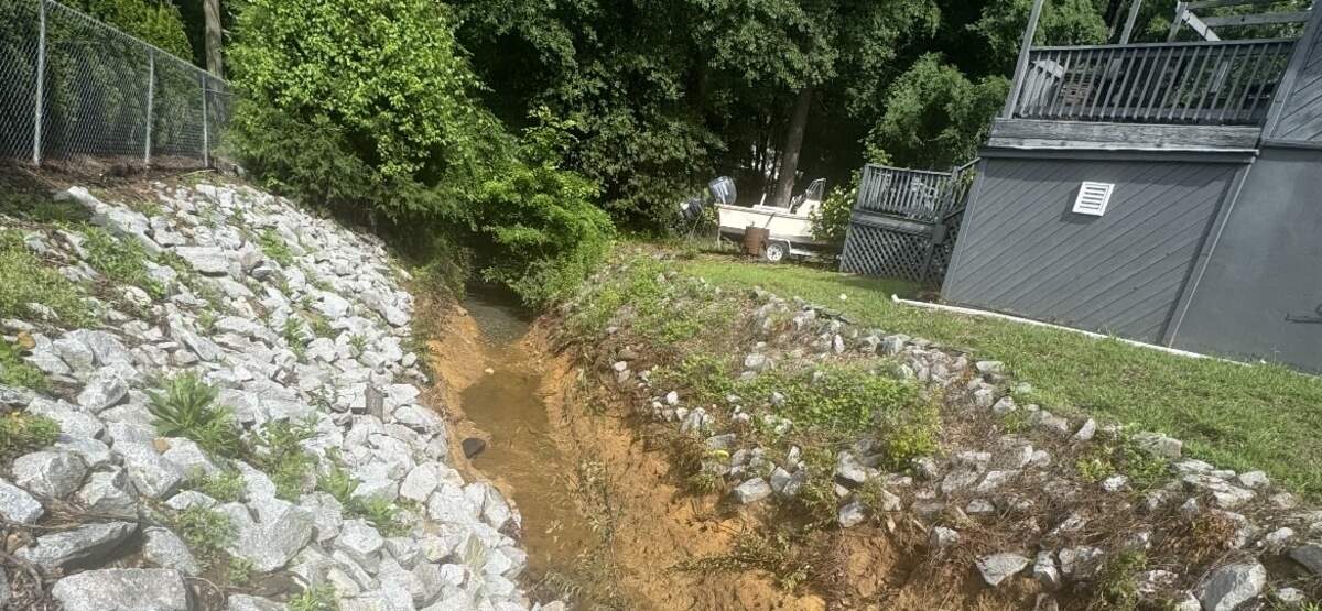Tracy Duckworth shows where rocks used to fill the normally-dry ditch directly by her property. Heavy rainfall in Irmo, South Carolina on Saturday, May 23, 2026 pushed the rocks into Lake Murray. Duckworth says erosion is beginning to threaten her home.