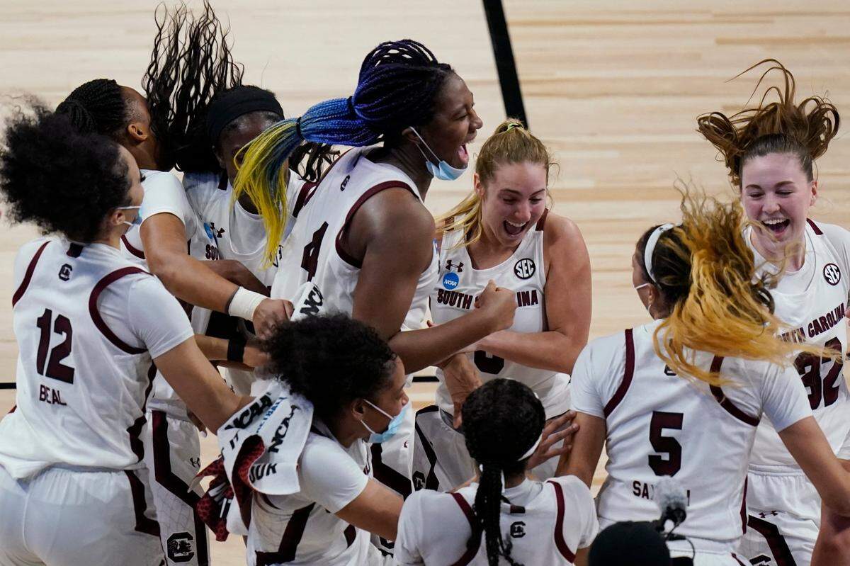 South Carolina players celebrate their win over Texas during in a college basketball game in the Elite Eight round of the women’s NCAA tournament at the Alamodome in San Antonio, Tuesday, March 30, 2021.