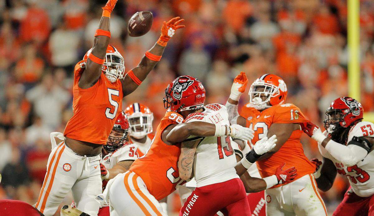 Clemson defensive end K.J. Henry (5) knocks down a pass thrown by N.C. State quarterback Devin Leary (13) as the QB is hit by defensive end Myles Murphy during second-quarter action in Clemson, S.C. on Saturday, Oct. 1, 2022.