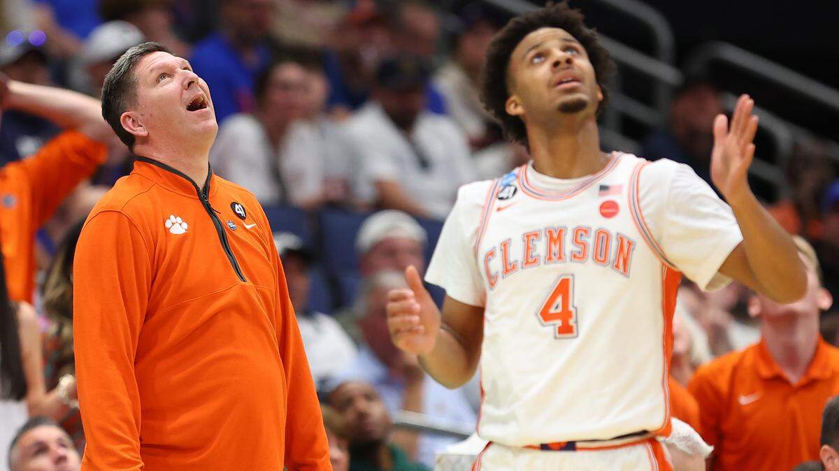 Head coach Brad Brownell and Butta Johnson #4 of the Clemson Tigers watch a replay on the scoreboard during the first half against the Iowa Hawkeyes in the first round of the 2026 NCAA Men's Basketball Tournament at Benchmark International Arena on March 20, 2026 in Tampa, Florida.