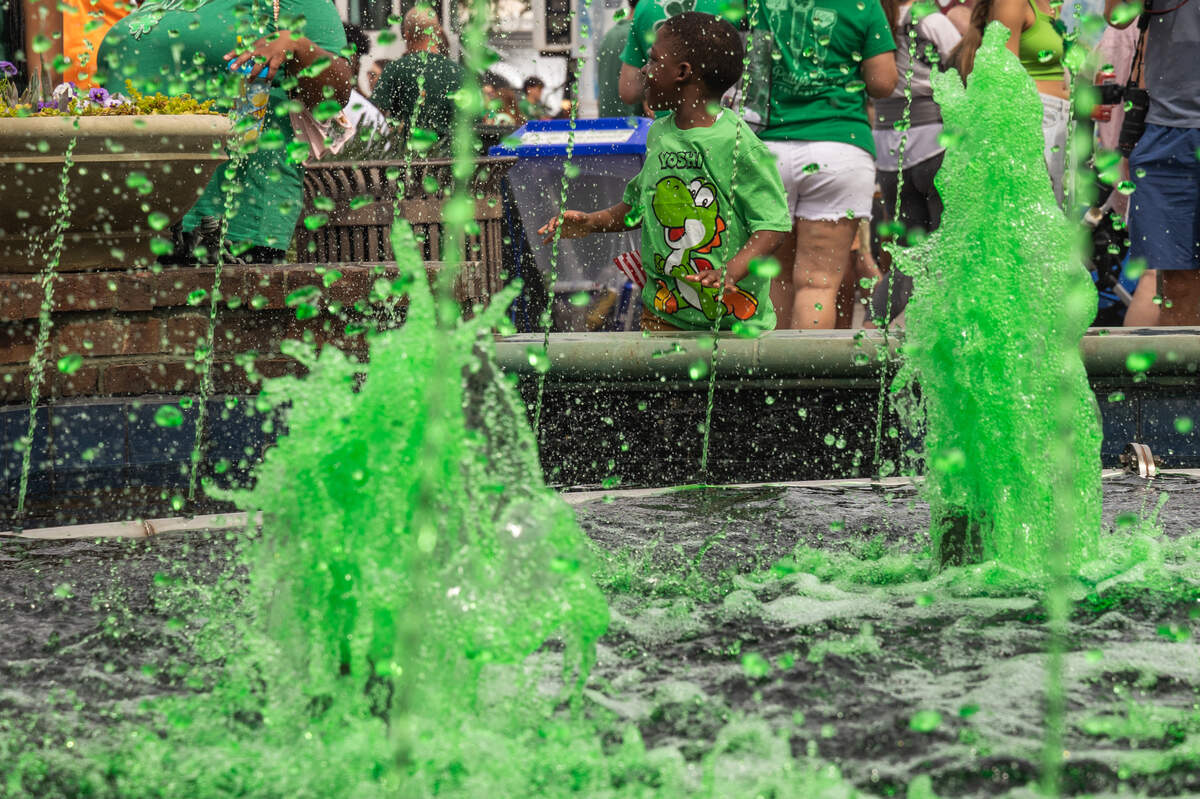 Children play near the dyed fountain during the St. Pat’s in Five Points festival in Columbia, South Carolina on Saturday, March 15, 2025.