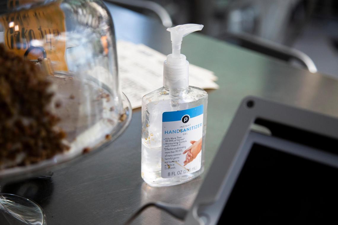 Business at Drip, a coffee shop in downtown Columbia, South Carolina, buzzes along normally on Thursday, March 12, 2020. Owner Sean McCrossin placed a hand sanitizer bottle next to the register and is using wipes that say they can kill the coronavirus more frequently around the coffee shop.