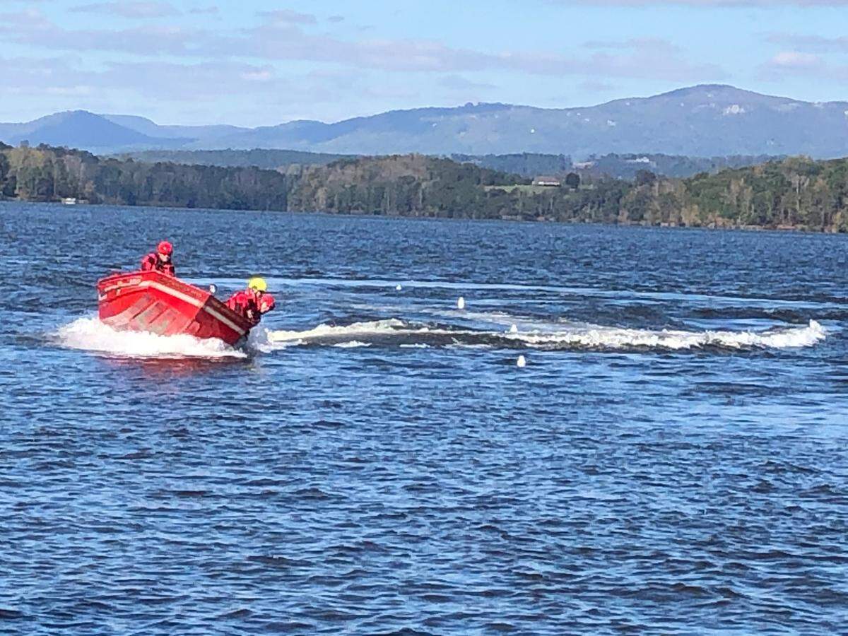 Rescue team attempts to keep a catamaran from going over the dam at Lake Robinson