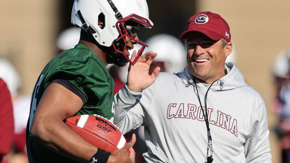 South Carolina quarterback LaNorris Sellers (16) jokes with head coach Shane Beamer while running drills during the Gamecocks’ practice in Columbia on Tuesday, March 19, 2024.