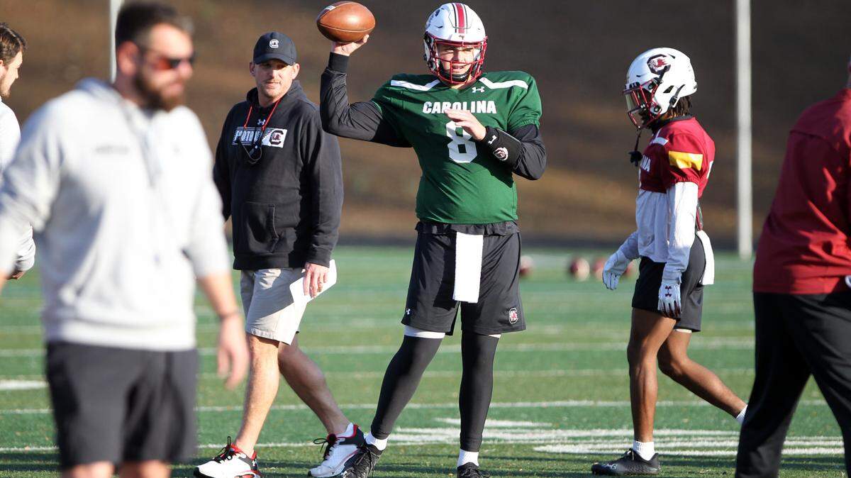 South Carolina quarterback Zeb Noland throws Monday at the Gamecocks’ bowl practice at Charlotte Christian School, with offensive coordinator Marcus Satterfield looking on.