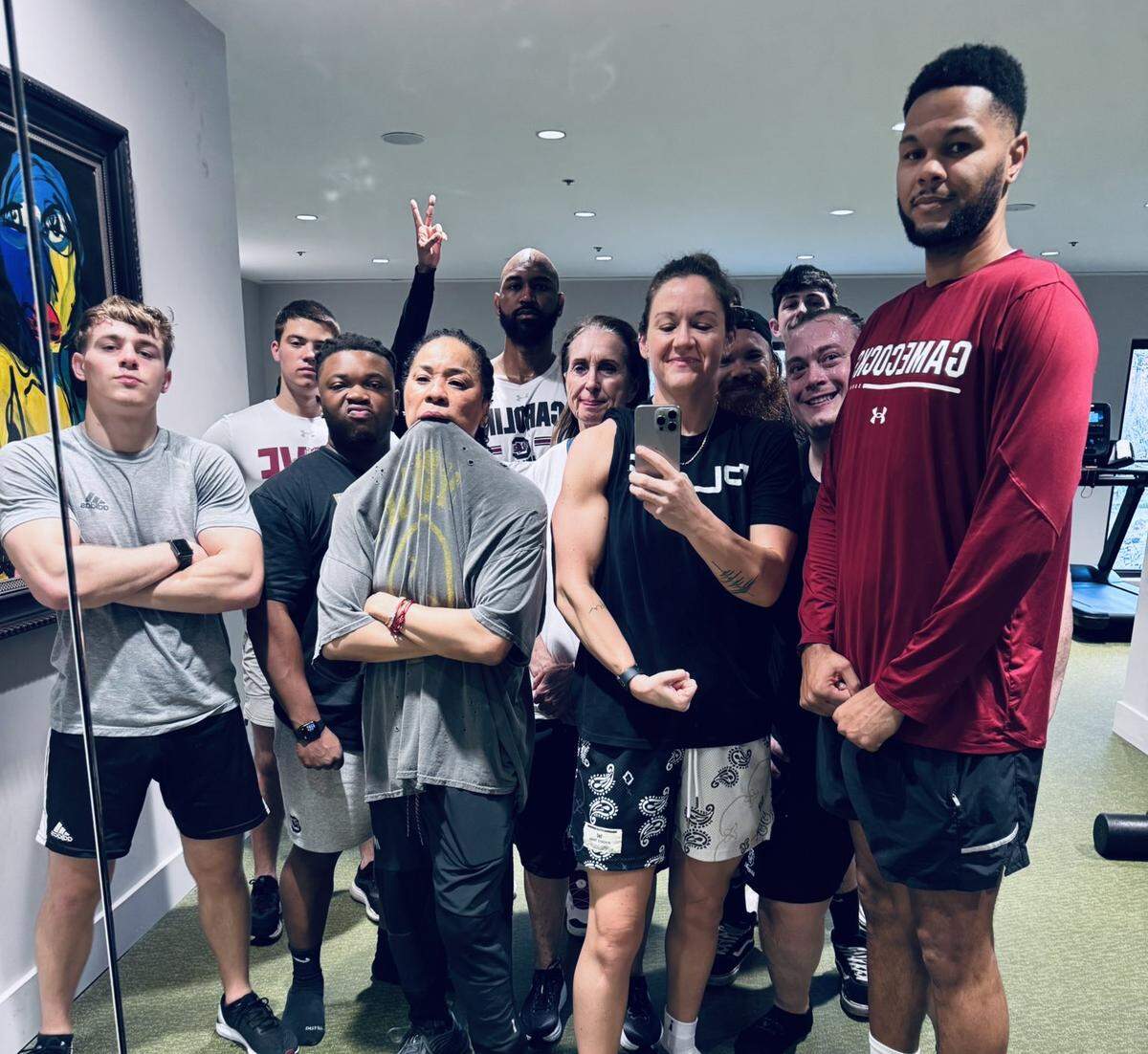 South Carolina women’s basketball sports performance coach Molly Binetti surrounded by head coach Dawn Staley and other members of the Gamecocks coaching/support staff at their regular pregame workout before the 2026 SEC Tournament championship game.