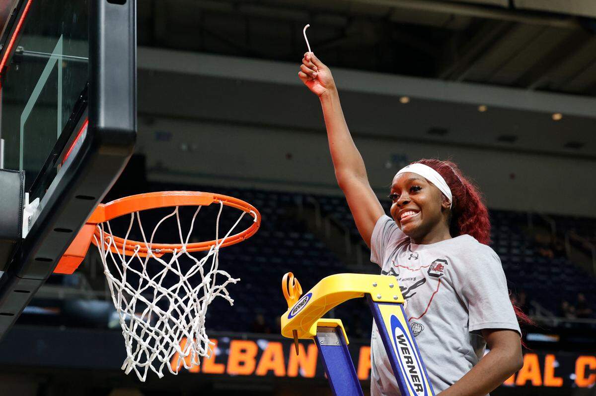 South Carolina’s Raven Johnson (25) celebrates winning the Albany Regional and advancing to the Final Four after cutting a piece of the net at the MVP Arena in Albany, New York on Sunday, March 31, 2024.