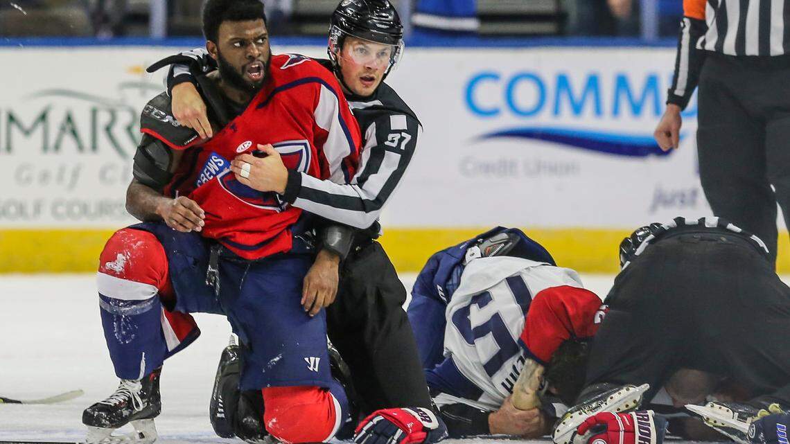 After an on-ice fight, South Carolina Stingrays defenseman Jordan Subban (5), left, is held by linesman Shane Gustafson while Jacksonville Icemen defenseman Jacob Panetta (15) is face-down on the ice engaged with another player during overtime of an ECHL hockey game in Jacksonville, Fla., Saturday, Jan. 22, 2022.