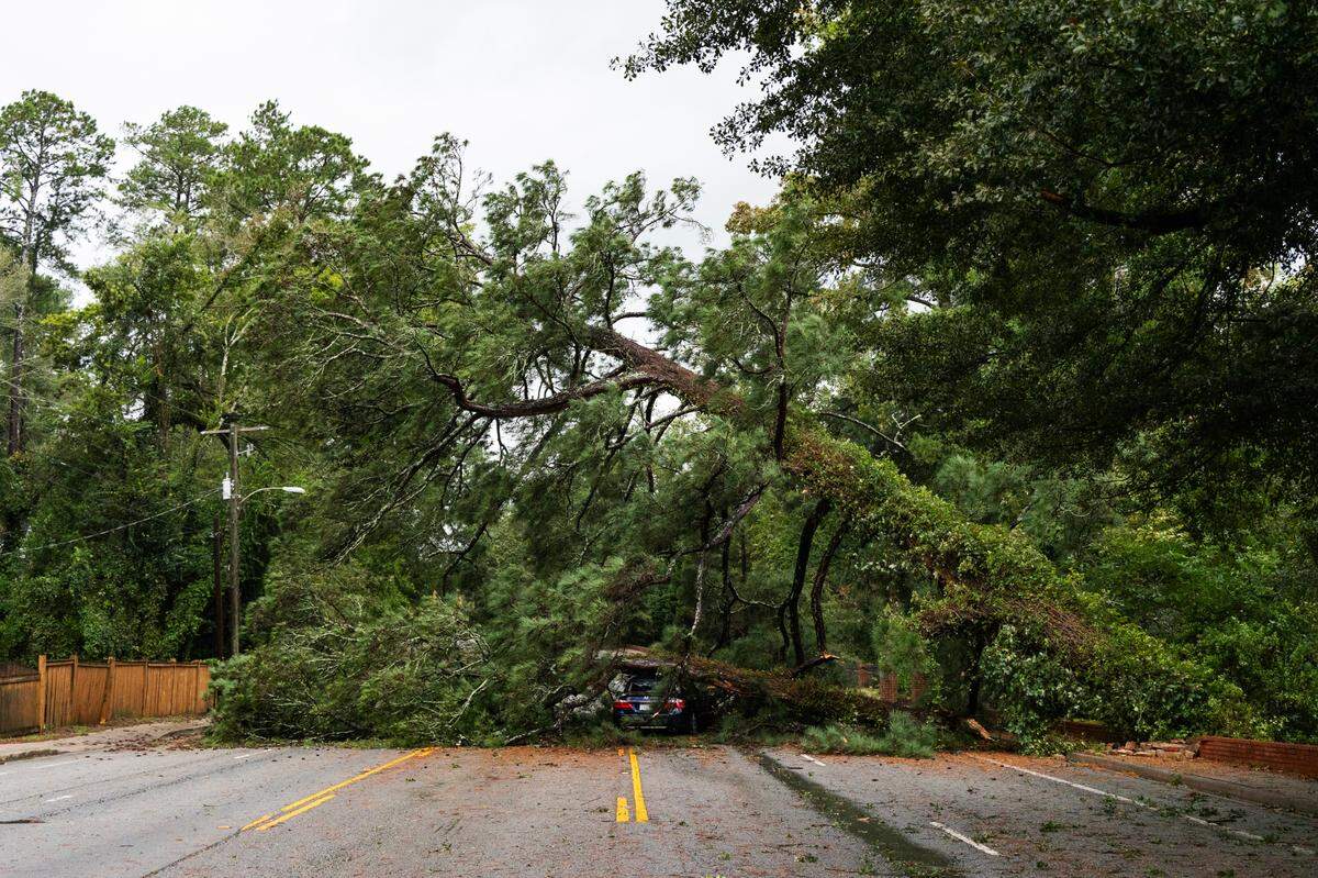 Two trees rest on a car on Trenholm Road near the intersection with Churchill Circle after Hurricane Helene hits Forest Acres, South Carolina on Friday, September 27, 2024.