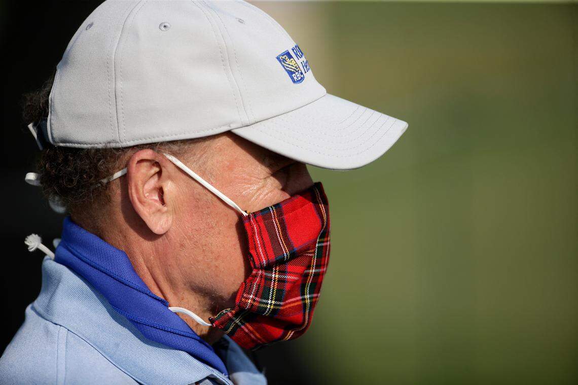A scorekeeper wears a mask to prevent the potential spread of the coronavirus on the 18th green during the final round of the RBC Heritage golf tournament, Sunday, June 21, 2020, in Hilton Head Island, S.C.