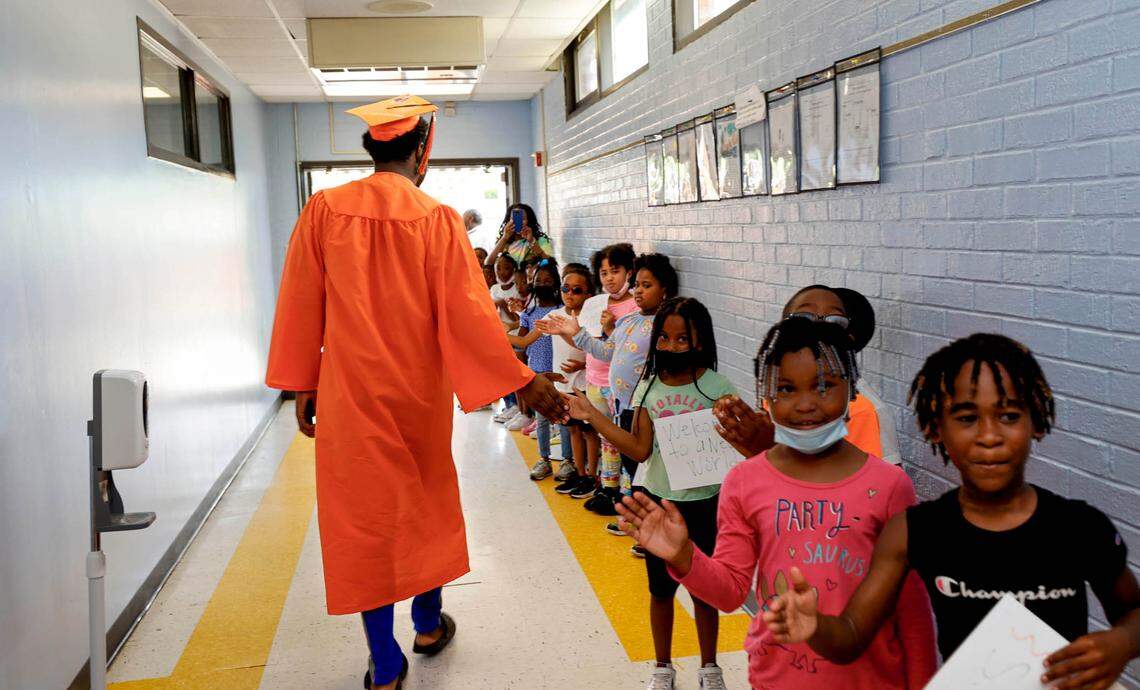 Eau Claire High School senior Tequan Green greets students at J.P. Thomas Elementary School as seniors tour the elementary and middle schools that near the high school.