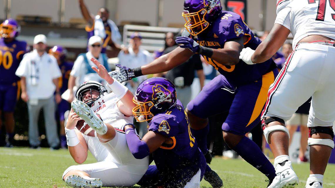 South Carolina’s Zeb Noland (8) gets tackled by East Carolina’s D’Angelo McKinnie (96) and Jeremy Lewis (11) during the first half of an NCAA college football game in Greenville, N.C., Saturday, Sept. 11, 2021. (AP Photo/Karl B DeBlaker)