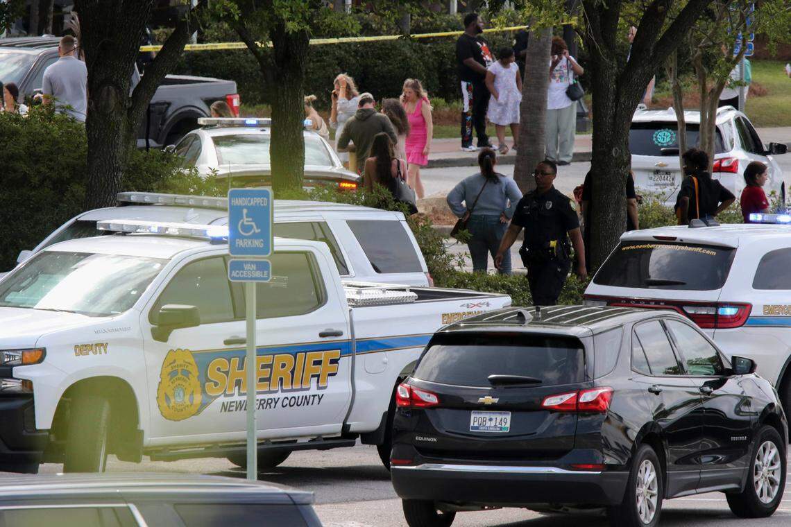 People who were inside the Columbiana Centre mall when a shooting occurred mill around with lawn enforcement personnel in Columbia, S.C. on Saturday, April, 16, 2022. At least three individuals with guns were detained after a shooting incident that left 12 people hurt.
