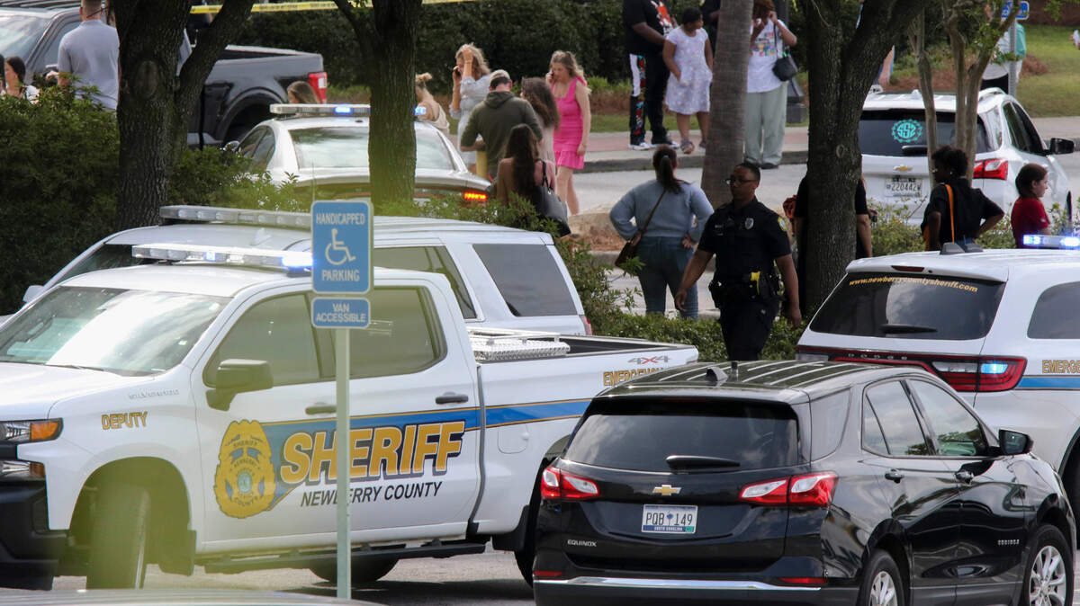 People who were inside the Columbiana Centre mall when a shooting occurred mill around with lawn enforcement personnel in Columbia, S.C. on Saturday, April, 16, 2022. At least three individuals with guns were detained after a shooting incident that left 12 people hurt.