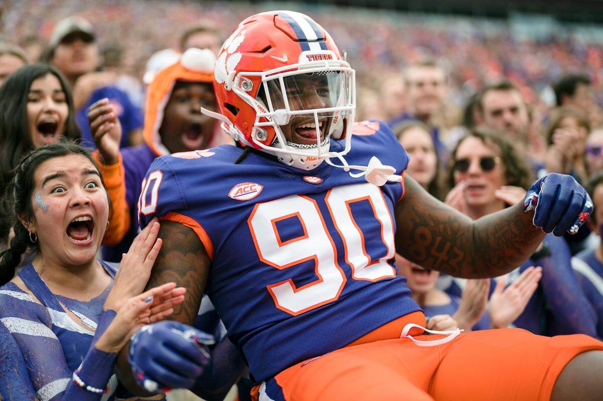 Clemson defensive tackle Jabriel Robinson (90) celebrates with student fans at the start of an NCAA college football game against Louisville, Saturday, Nov. 12, 2022, in Clemson, S.C. (AP Photo/Jacob Kupferman)