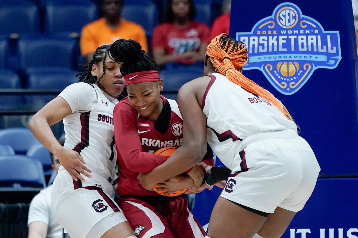 Arkansas’ Erynn Barnum, center, wrestles for the ball with South Carolina’s Zia Cooke, left, and Aliyah Boston, right, in the first half of an NCAA college basketball game at the women’s Southeastern Conference tournament Friday, March 4, 2022, in Nashville, Tenn. (AP Photo/Mark Humphrey)
