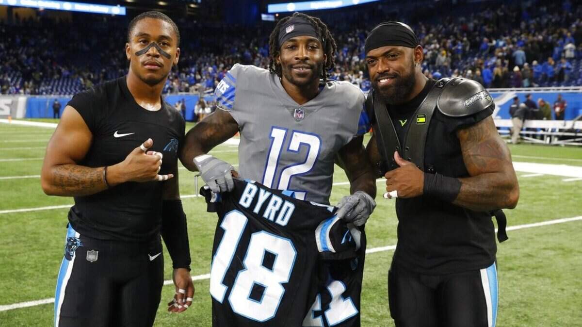 Former South Carolina players, Carolina Panthers wide receiver Damiere Byrd, left, and defensive back Captain Munnerlyn, right, pose with Detroit Lions wide receiver Bruce Ellington (12) after swapping jerseys after an NFL football game, Sunday, Nov. 18, 2018, in Detroit.