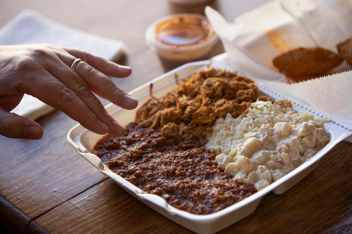 The State reporter Chris Trainor gestures to a box of barbecue at Ward’s Barbecue in Sumter, South Carolina on February 10, 2022.