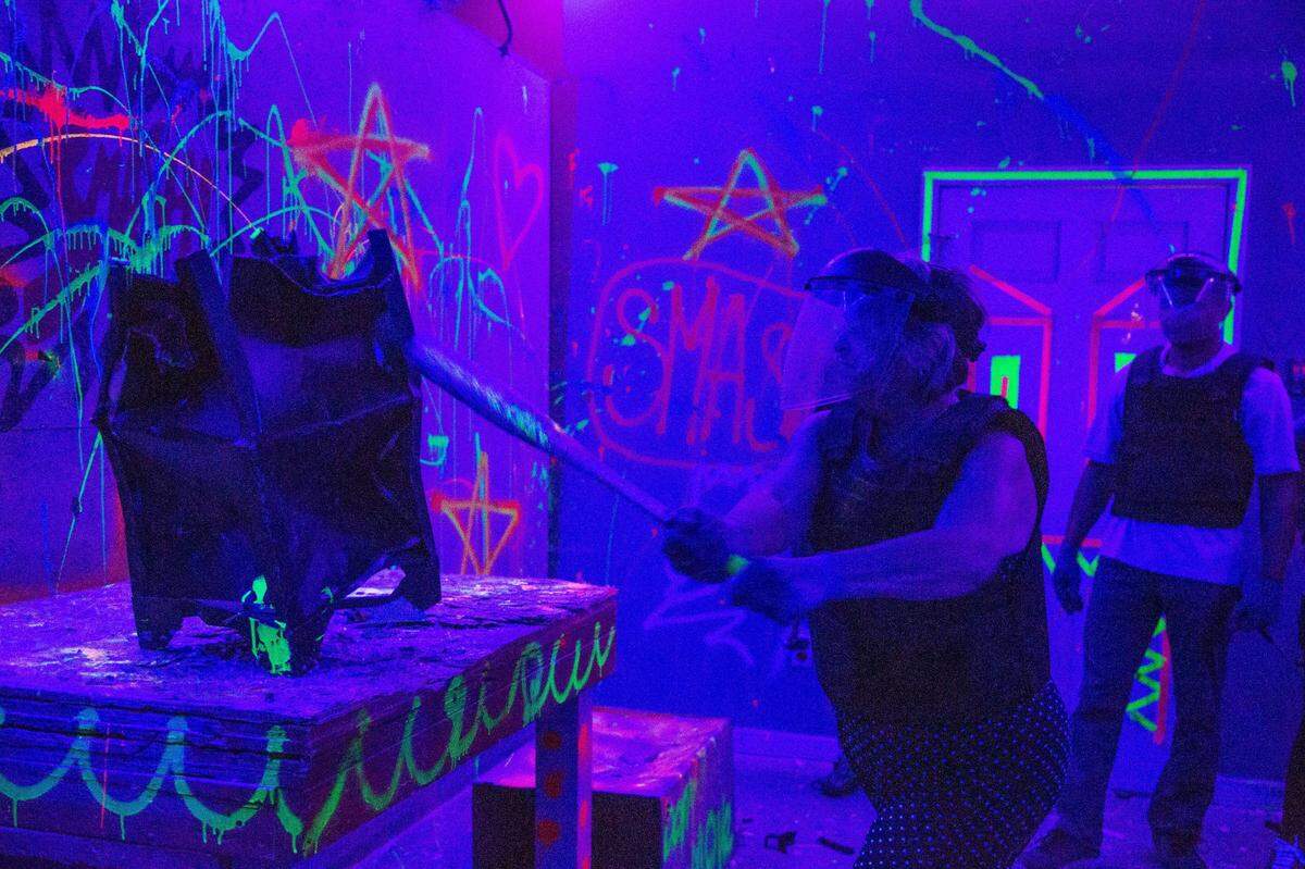 Tamara Bundrick uses a baseball bat to hit a piece of furniture that has been deformed beyond recognition at the SC Riot Room on Friday, July 16, 2021. Bundrick was taken to the smash room as a surprise by her daughters.