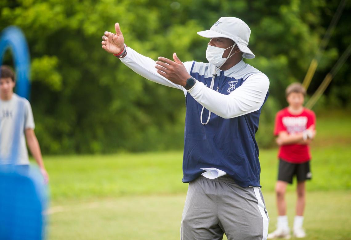 Assistant coach Andrew Richardson directs his players during football practice at Heathwood Hall. In addition to temperature checks, players arrived at staggered times, practiced in groups no larger than nine, are required to bring their own mask and water, and stand on assigned spots on the field, spaced away from teammates.