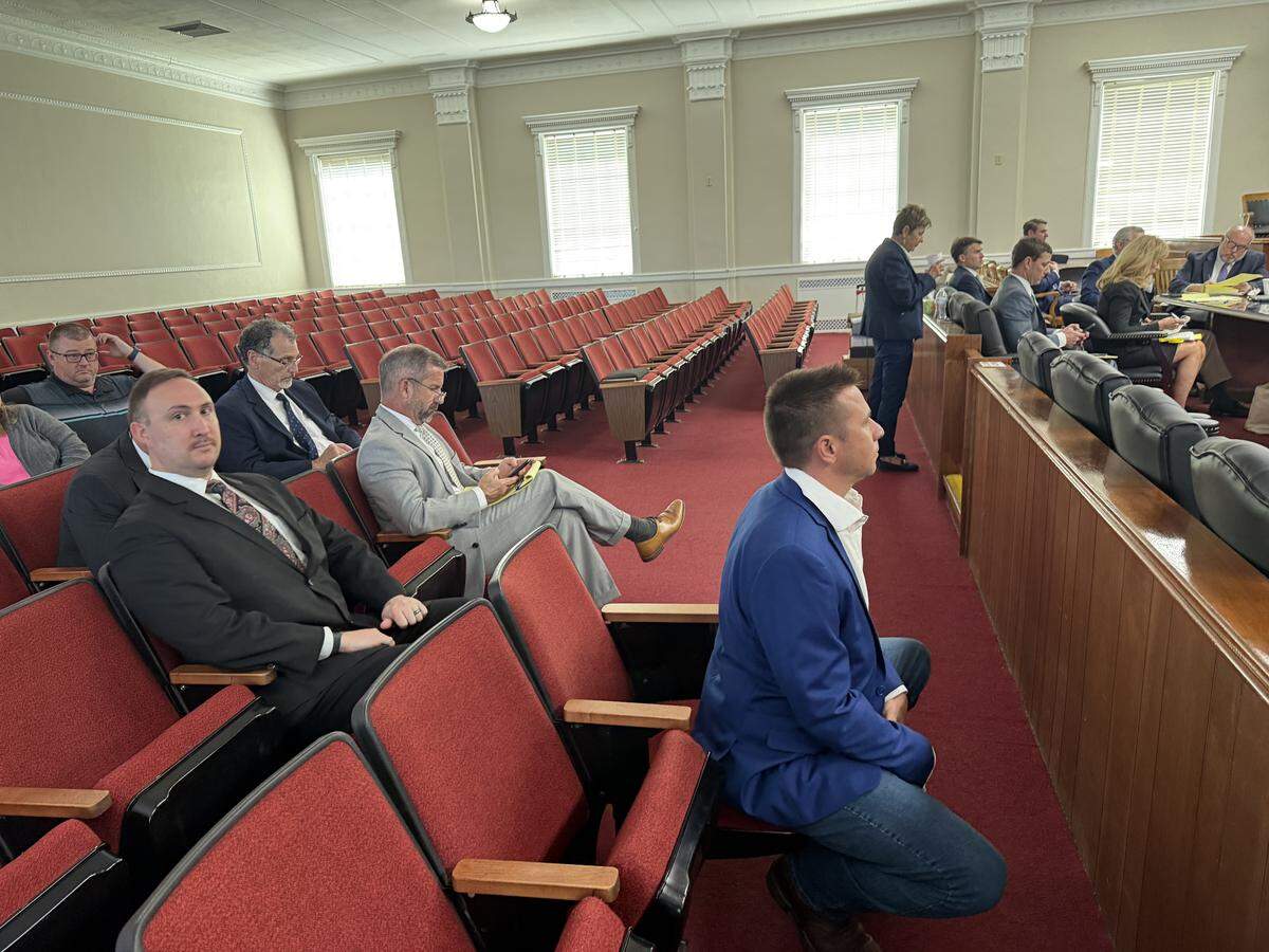 David Moses (in blue jacket), Mandy Matney’s husband and business partner, sat attentively during the entire nearly three-hour hearing as his wife testified. Behind Moses in the dark suit is Matney’s bodyguard.