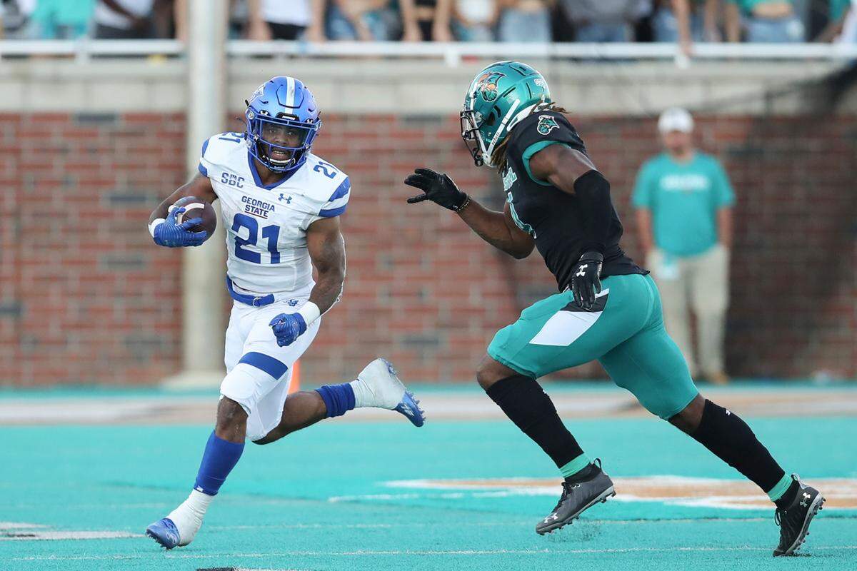 Georgia State running back Jamyest Williams (21) runs away from Coastal Carolina safety Kendricks Gladney Jr. (4) during the second half of an NCAA college football game Saturday, Nov. 13, 2021, in Conway, S.C. (AP Photo/Artie Walker, Jr.)