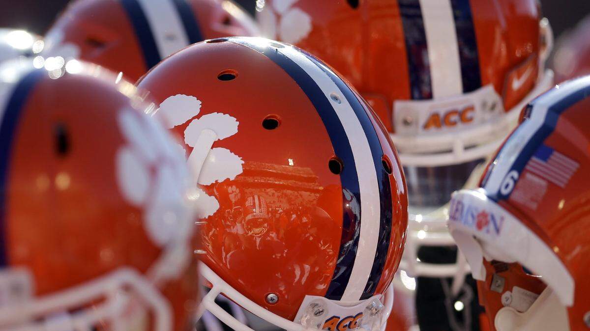 Clemson players lift their helmets into the air as they huddle before an NCAA college football game against Maryland in College Park, Md., Saturday, Oct. 26, 2013. (AP Photo/Patrick Semansky)