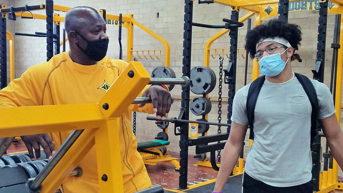 North Central High School football coach Tyronne Drakeford, left, talks with defensive back Justin Porter during a workout on Tuesday, June 16, 2020.