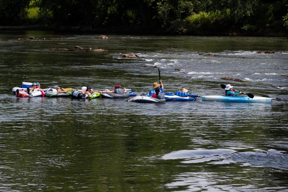 A group of float trippers are guided over rocks by a person in a kayak near the West Columbia Riverwalk Park and Amphitheater on Saturday, July 10, 2021.