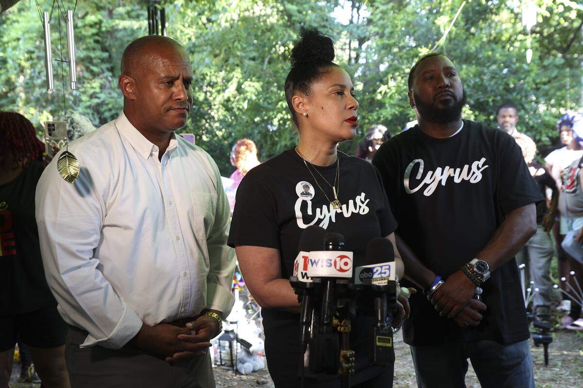 Nicole Carmack, Troy Belton, and their attorney Todd Rutherford, speak to the media during a memorial Wednesday, June 3, 2026 for Cyrus Carmack-Belton along Springtree Drive where he was killed in 2023.