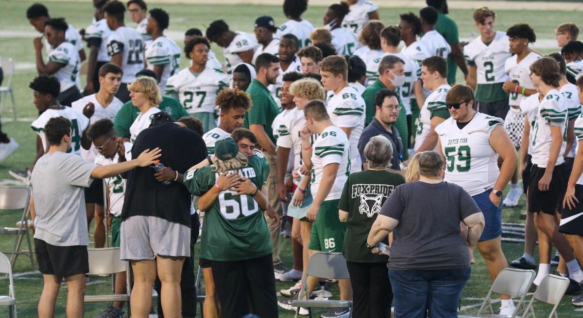 Family members and football players embrace at Dutch Fork High School football stadium Aug. 27 after paying their respects to Jack Alkhatib, a senior and a football player who collapsed and died Aug. 24 at a practice.