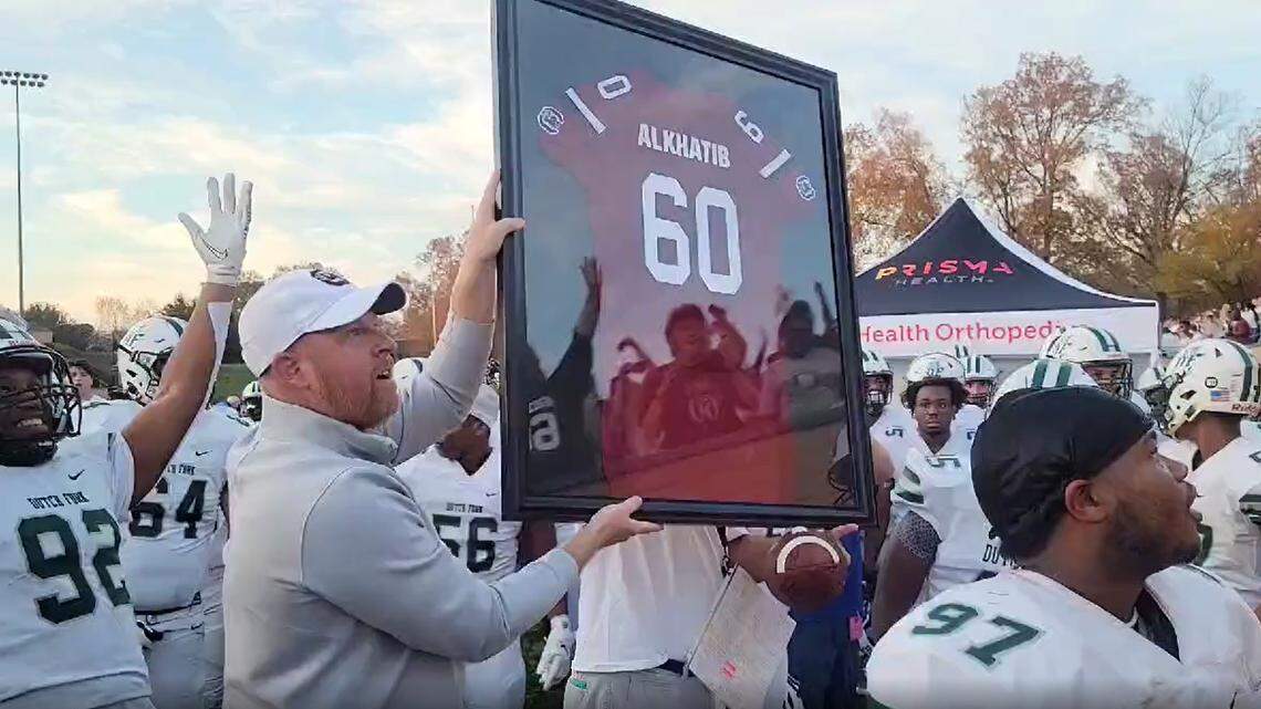 Erik Kimrey presents Kelly Alkhatib with a No. 60 Gamecocks jersey before the Dutch Fork game Saturday.