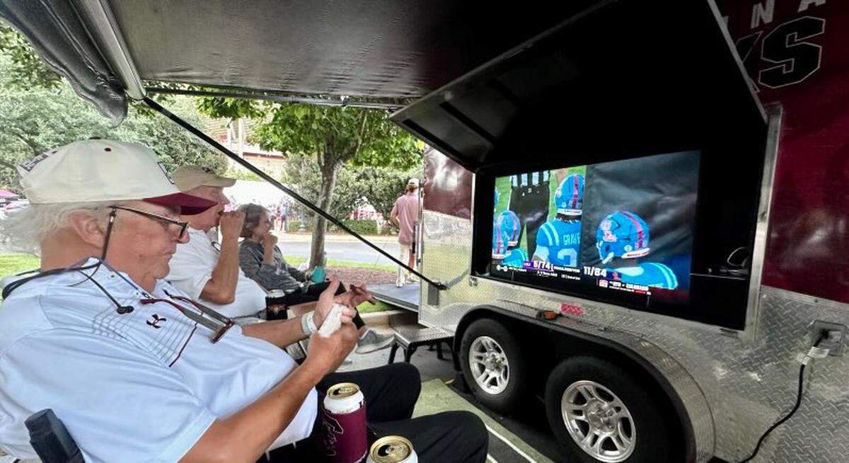 Joe Rice hangs out his tailgate set up in late September, watching an SEC football game while smoking a cigar.